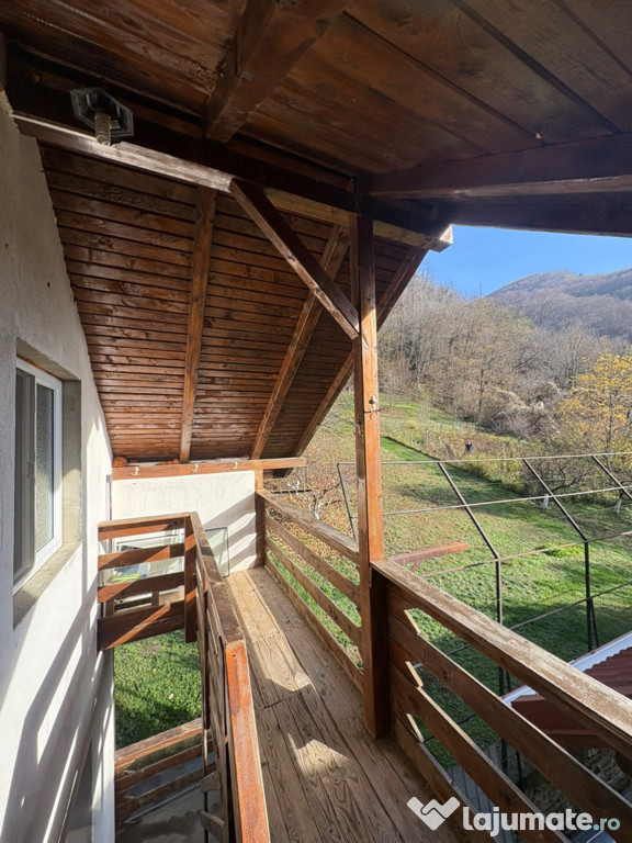 Casă la poalele munților, pe malul râului