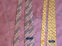 Două cravate de lux: una Salvatore Ferragamo și una Burberry.
